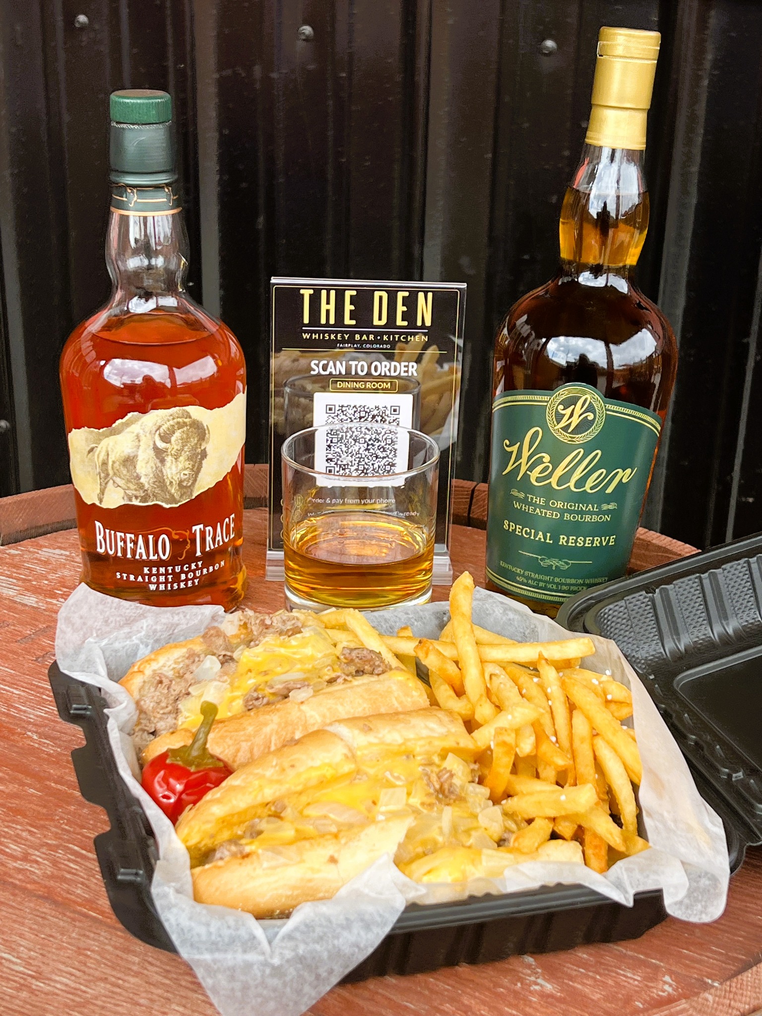 Whiskey and a cheesesteak with fries at The Den